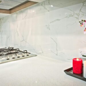 Stylish kitchen interior featuring decorative candles and orchids on a countertop.