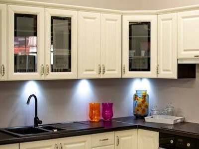 A stylish modern kitchen with white cabinets and colorful decor pieces.